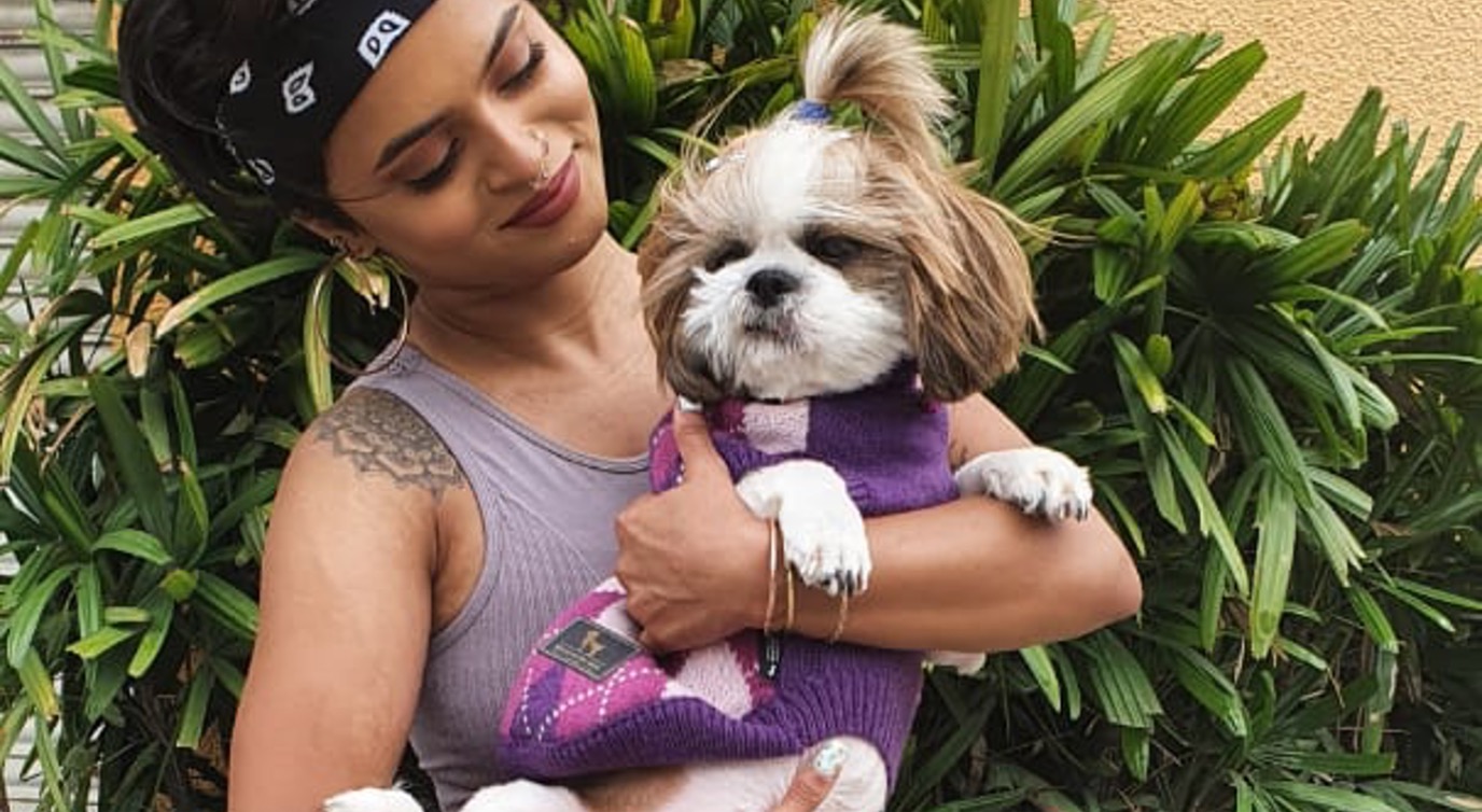 A girl with her dog during her workout with sports wear